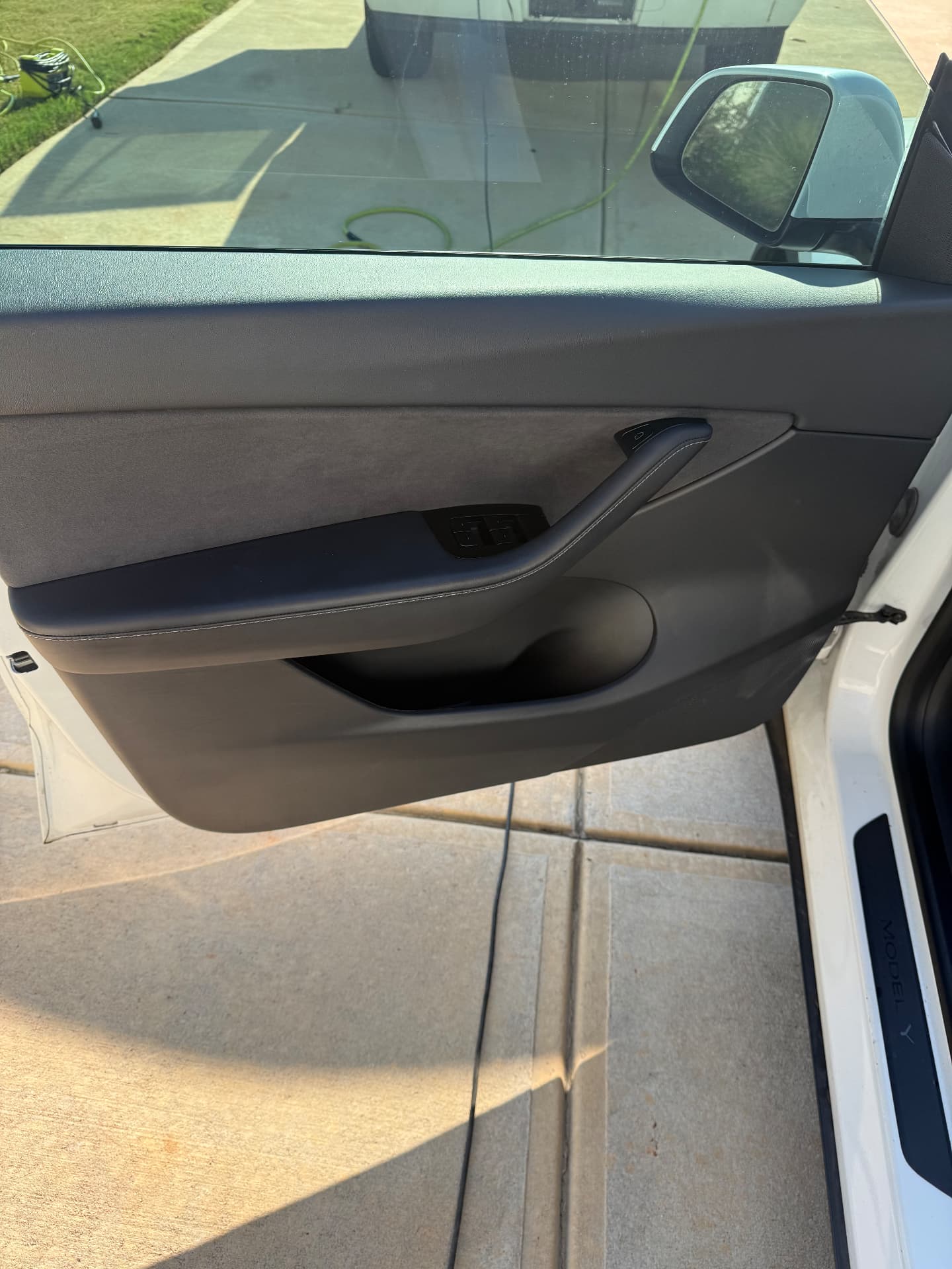 Cleaned and conditioned grey leather Tesla Model Y door panel after leather care in Atlanta